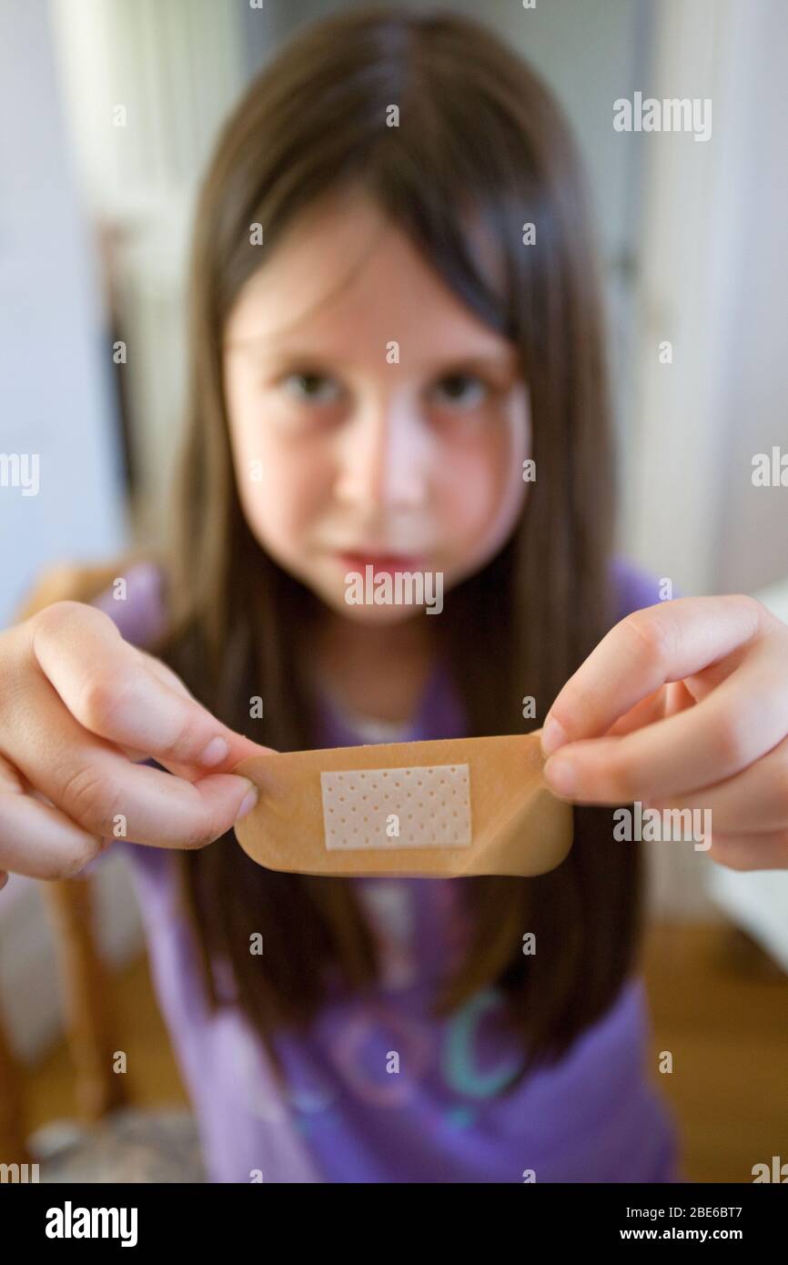 Young girl holding up a band aid towards camera Stock Photo Alamy