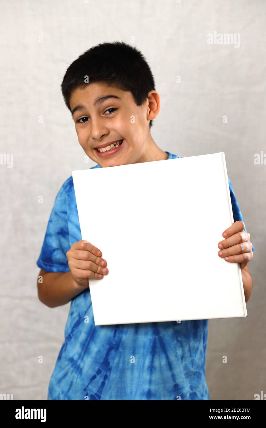 A boy holding a white board on a white background Stock Photo - Alamy