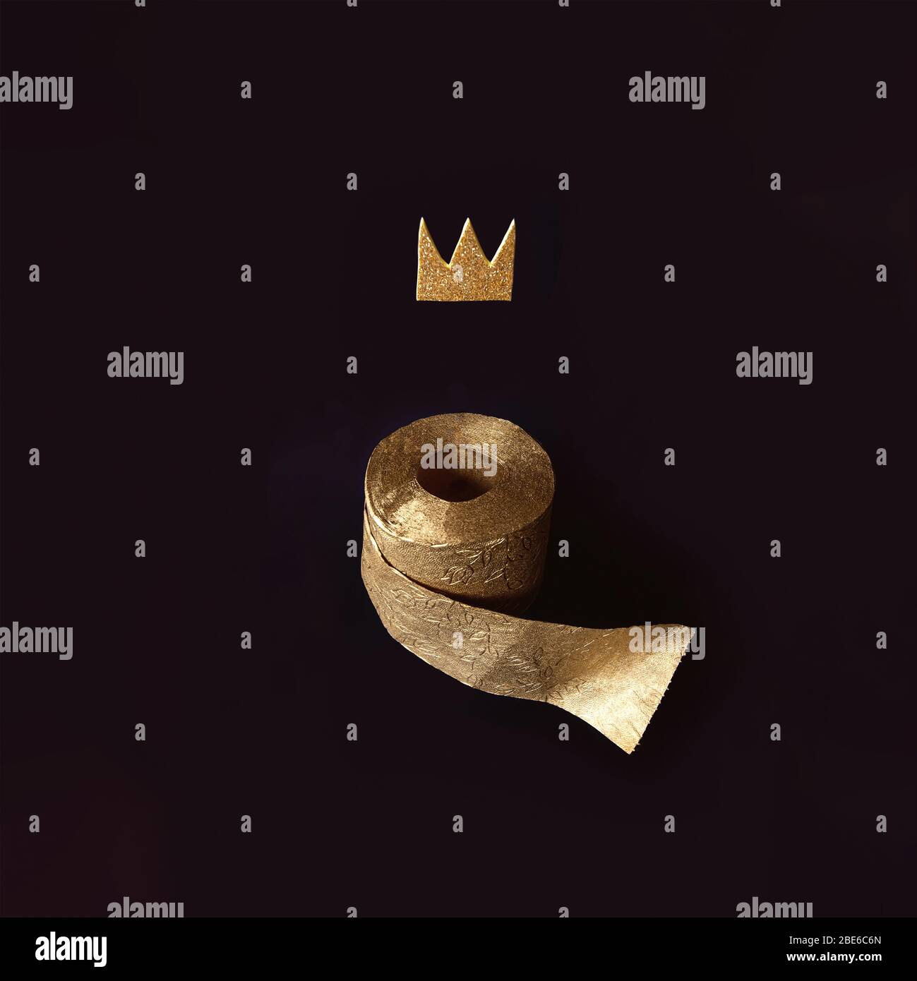 Gold toilet paper with a crown on a black background. A concept on the topic of coronavirus and pandemic. Stock Photo