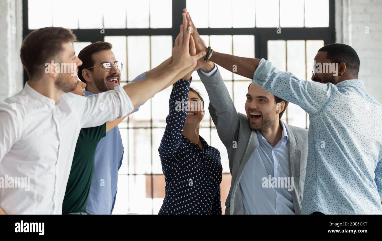 Overjoyed diverse colleagues give high five celebrating success Stock ...