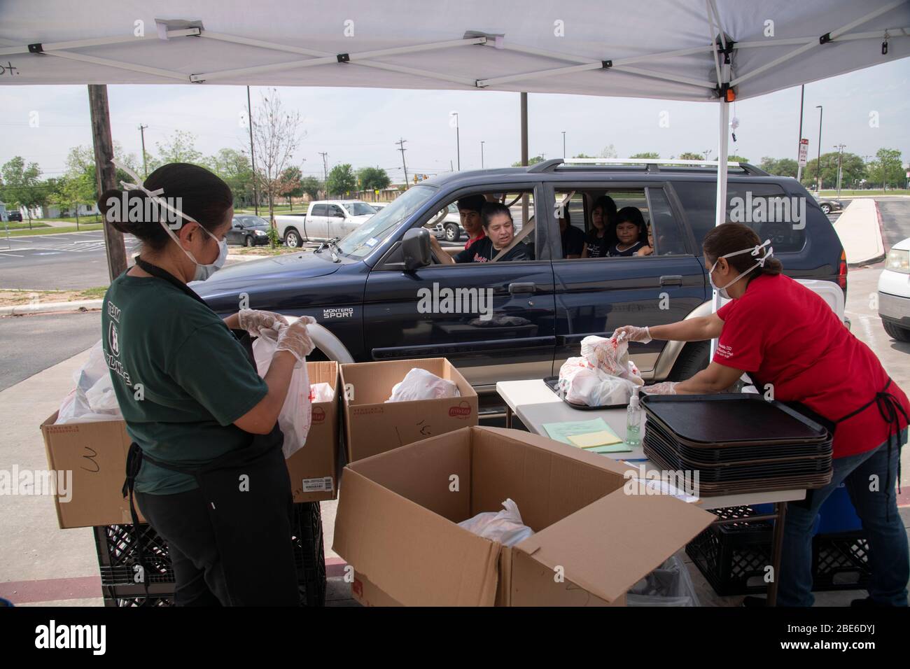 Child Nutrition Staff Isabel Rosales and Maria Sauceda set out meal bags for families suffering from the COVID-19, coronavirus pandemic April 8, 2020 in San Antonio, Texas. The USDA Food and Nutrition Service is  distributing meals for school children at locations across the country. Stock Photo