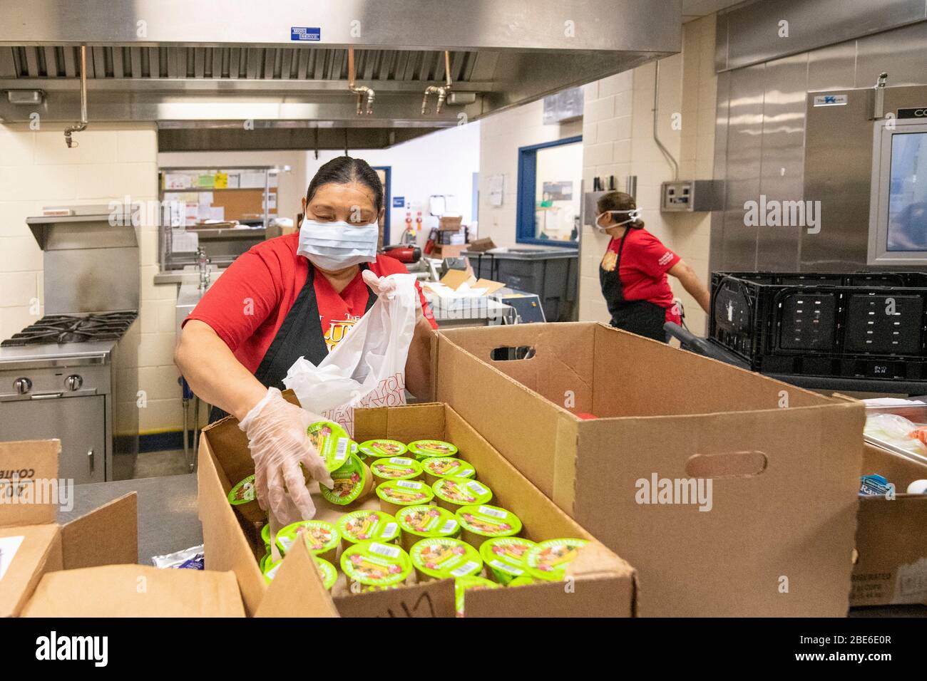 Child Nutrition Staff pack meal bags for families suffering from the COVID-19, coronavirus pandemic April 8, 2020 in San Antonio, Texas. The USDA Food and Nutrition Service is  distributing meals for school children at locations across the country. Stock Photo
