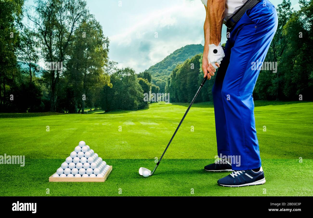 Golf player practicing in a driving range with pyramid of golf balls