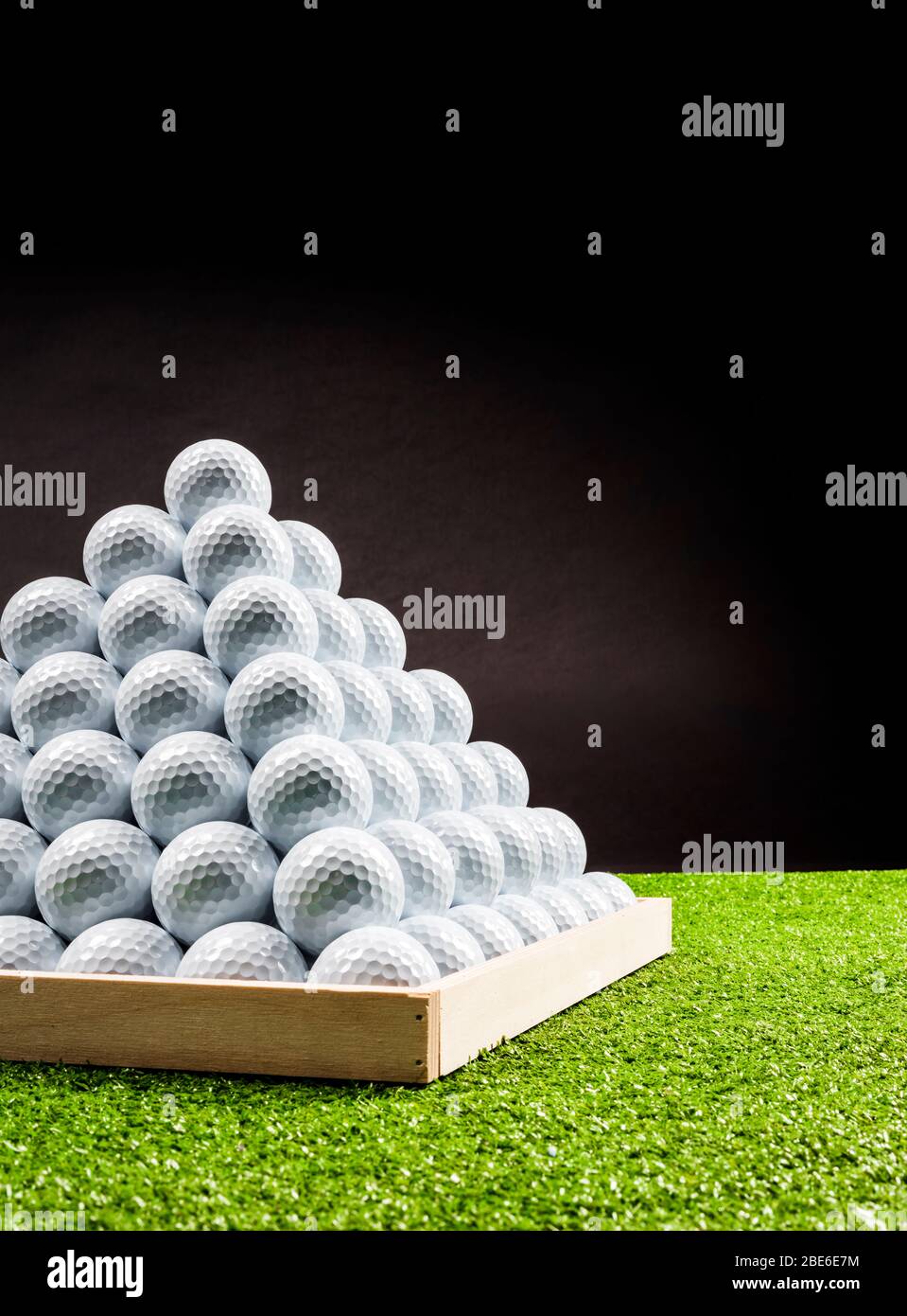 Close up of pyramid of golf balls in a driving range, side view