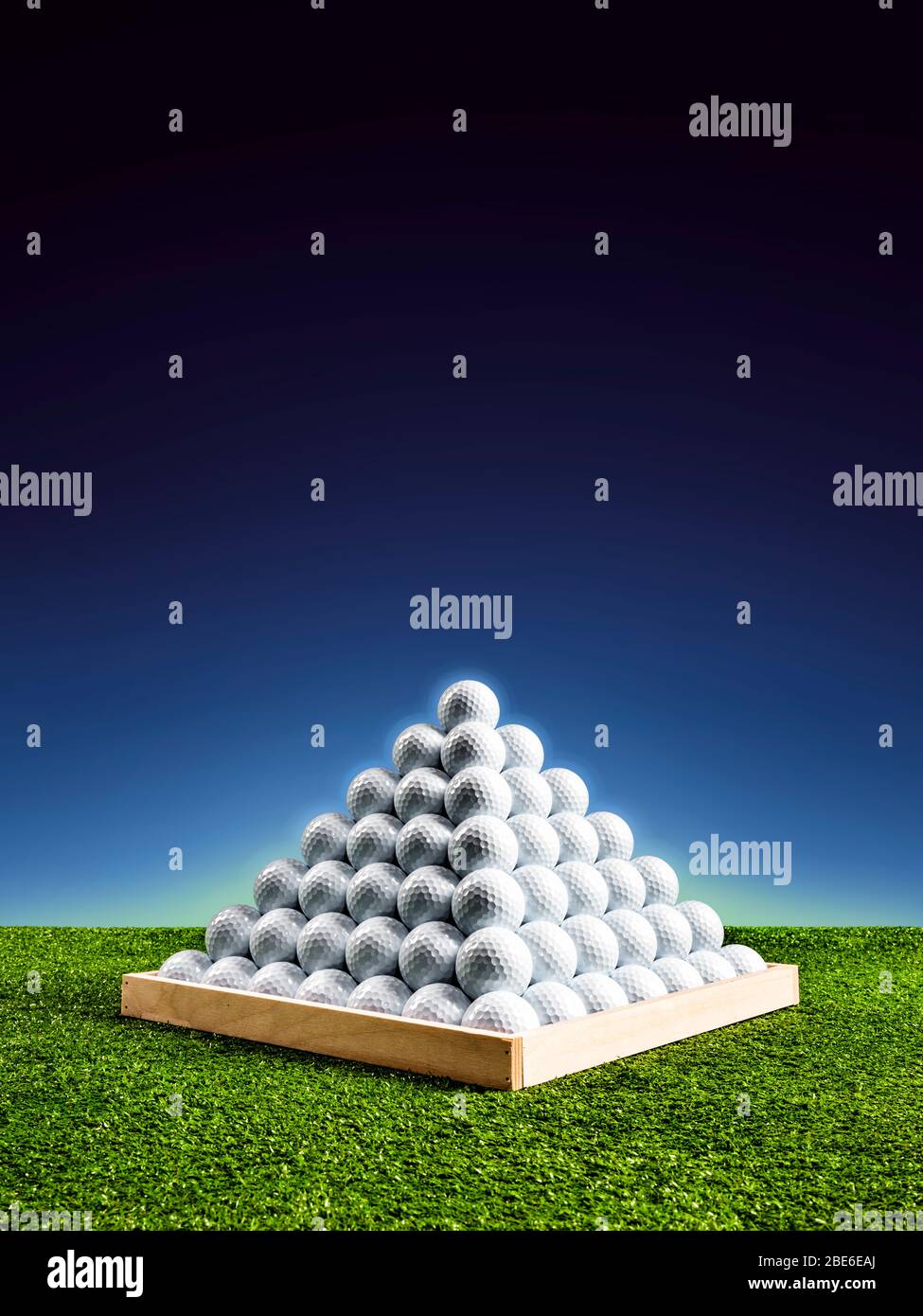 Pyramid of golf balls in a driving range with blue light glow, vertical