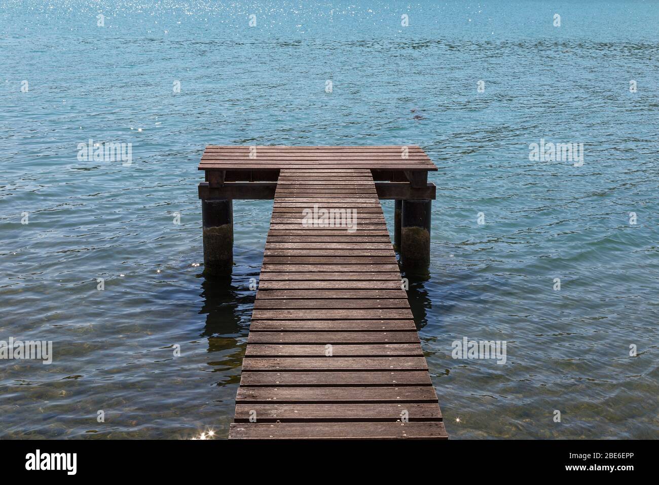 wooden pier surrounded by the blue sea Stock Photo