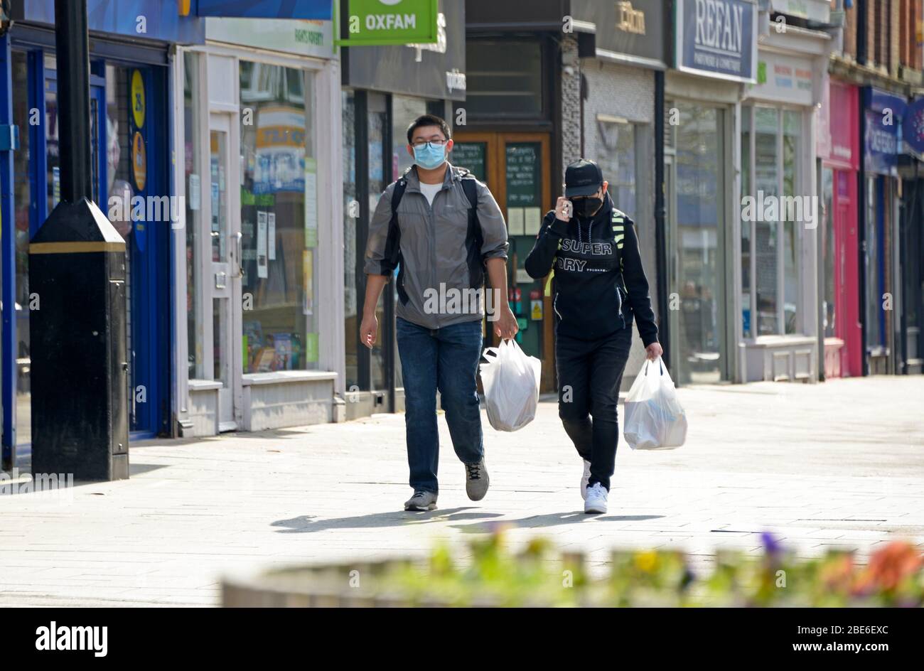 Two people out shopping, with masks, during Corona virus lock down Stock Photo