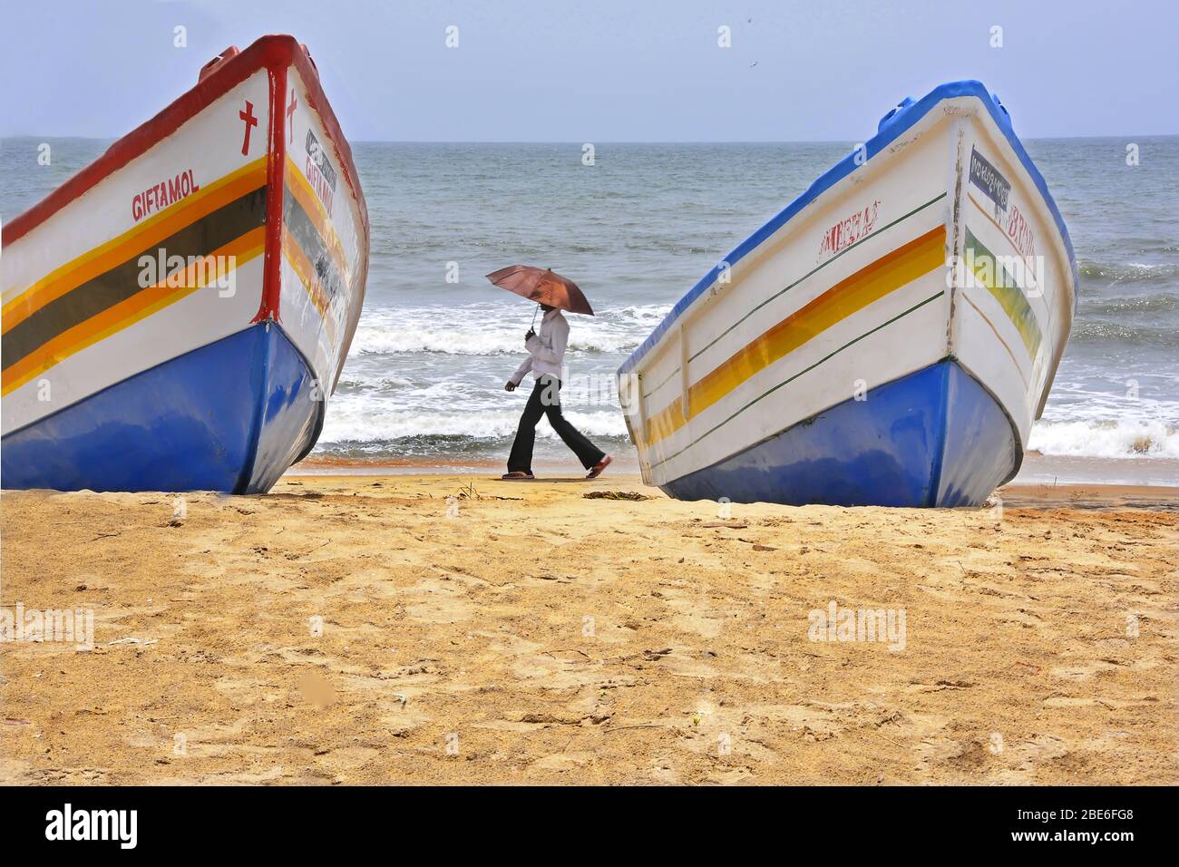 fishing boats and a man at chavakkad beach kerala india Stock Photo