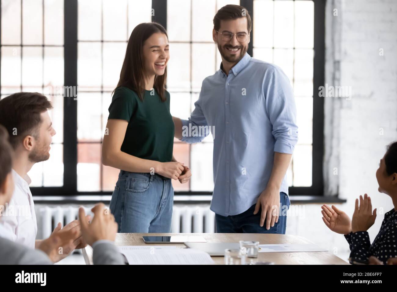Male employer introduce new excited female employee at meeting Stock Photo