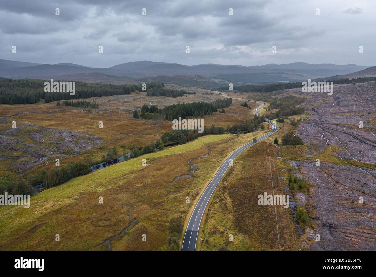 Drone shoot at autumn over empty asphalt road A87 near Loch Loyne in in the Northwest Highlands of Scotland Stock Photo