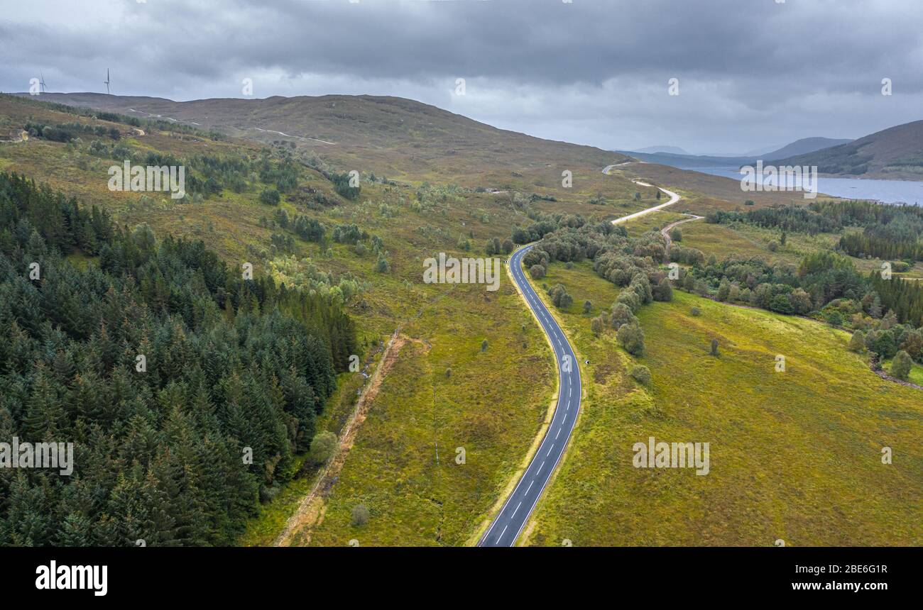 Drone shoot at cloudy autumnal morning over empty asphalt road A87 near Loch Loyne in in the Northwest Highlands of Scotland Stock Photo