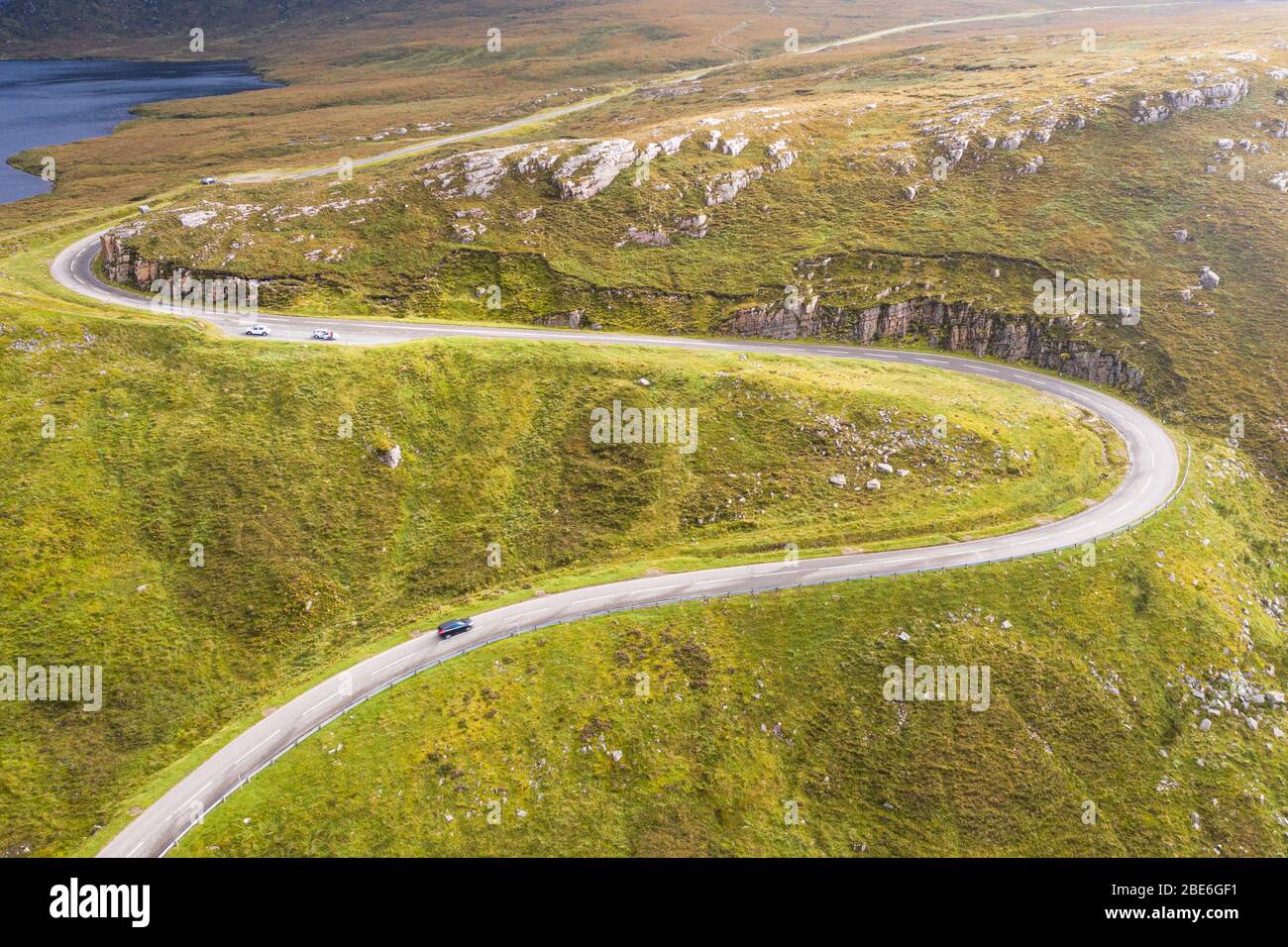 Drone shoot over curvy asphalt road A894 near the Quinag Mountain in the North West Highlands of Scotland - NC500 Route Stock Photo