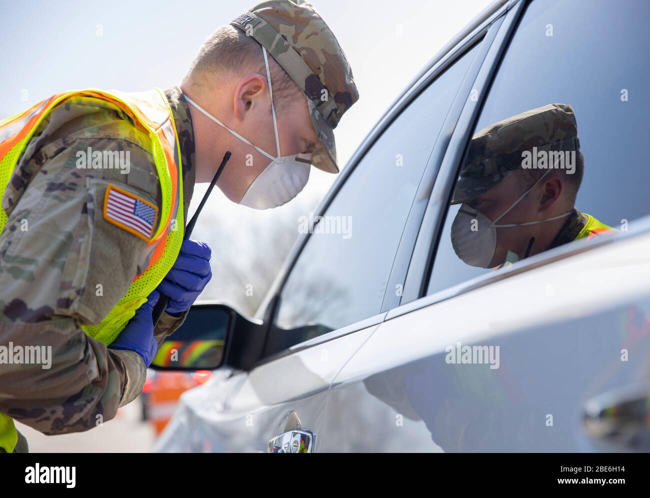 New York Army National Guard Spc. Ryan Gallagher gives instructions to people in their vehicles at the COVID-19 Mobile Testing Center at Glenn Island Park April 8, 2020 in New Rochelle, New York. Stock Photo