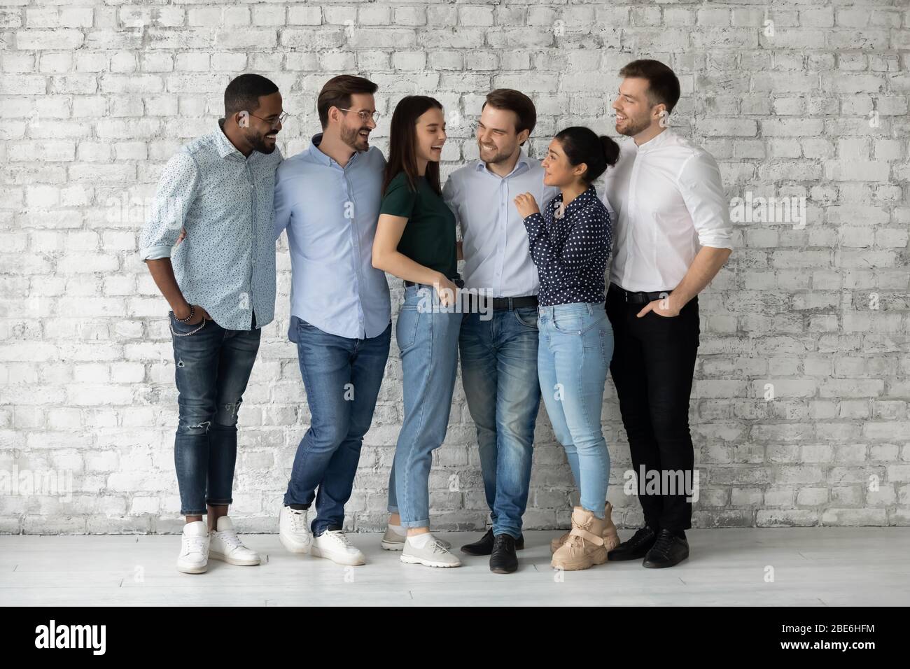 Happy multiracial businesspeople have fun talking at workplace Stock Photo