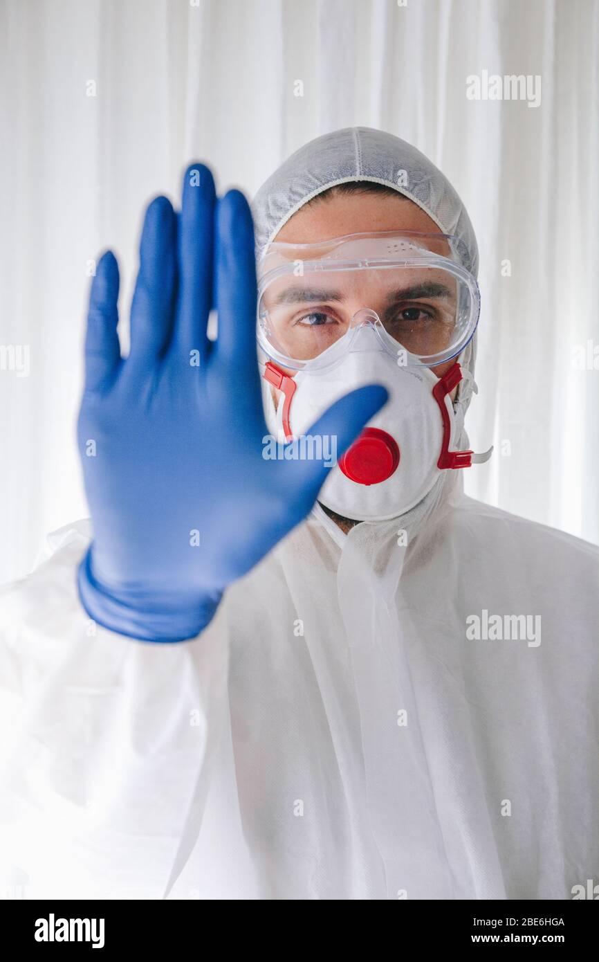 Doctor in protective suit and face mask making stop gesture stock photo Stock Photo