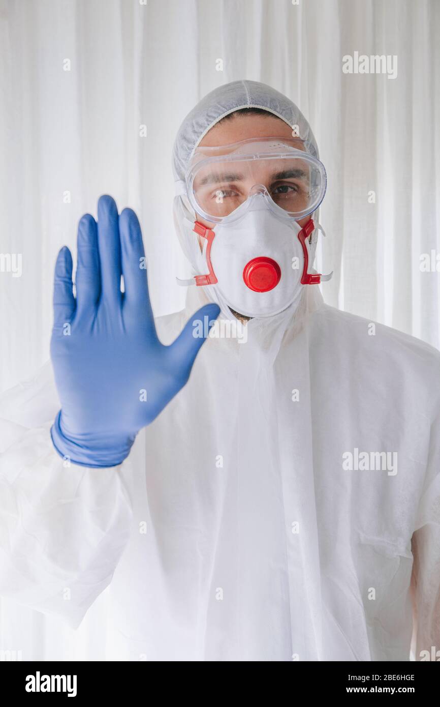 Doctor in protective suit and face mask making stop gesture stock photo Stock Photo