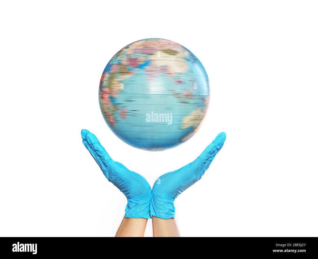 Hands in medical gloves holding turninig globe on a white background. COVID-19 pandemic concept. Stock Photo