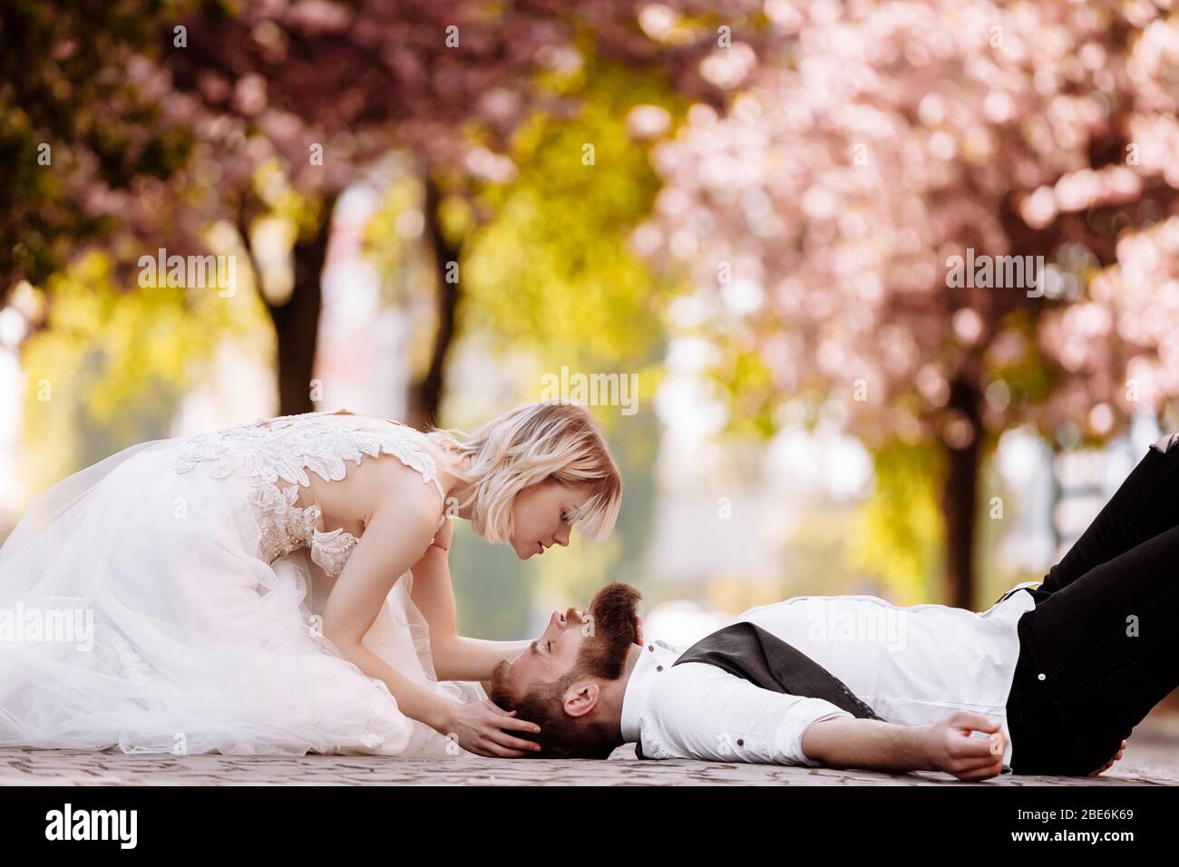 stylish couple lying on the ground in old town in spring. couple ...