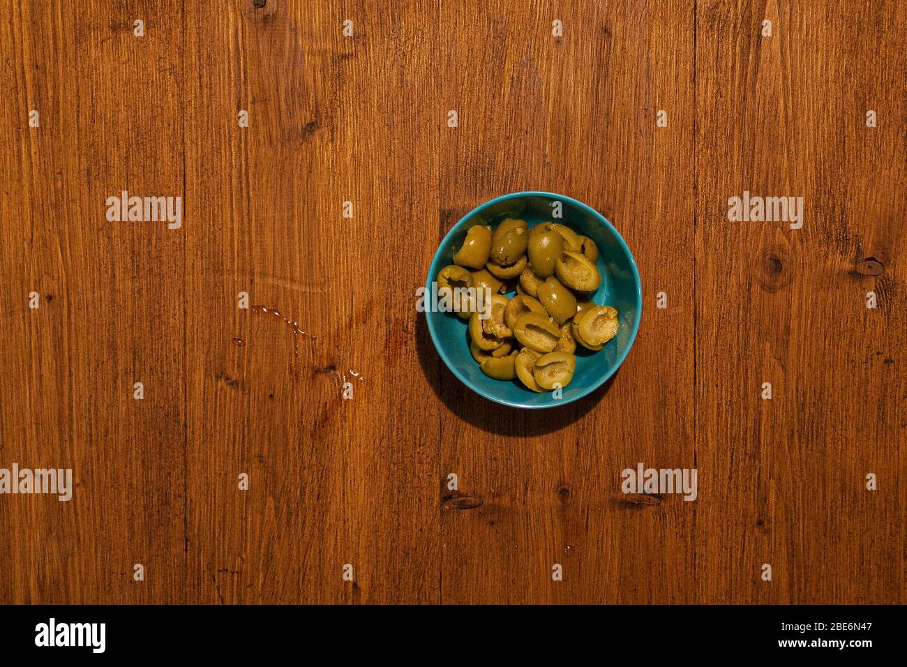 Top view of bowl full of olives on wooden background Stock Photo
