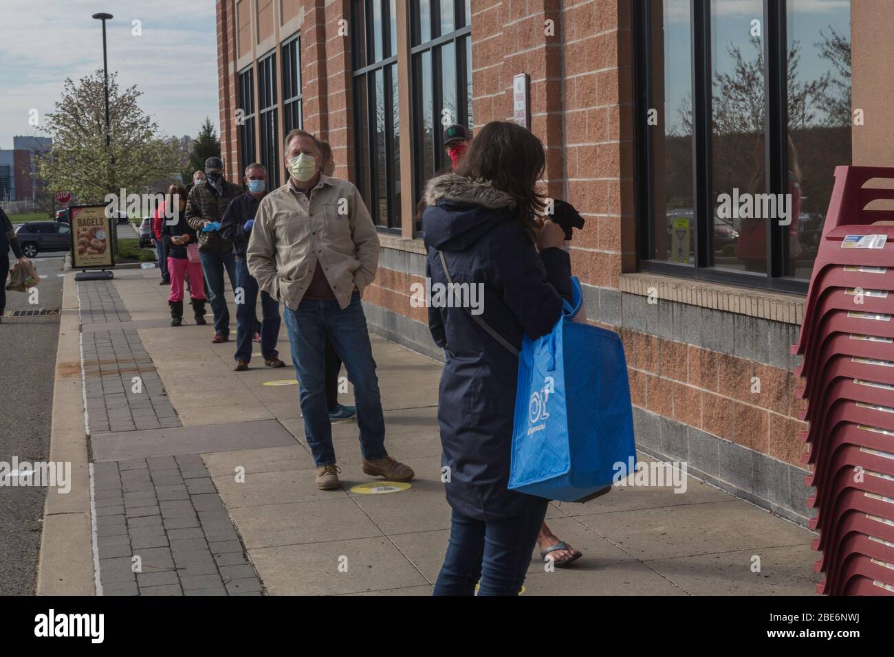 Covid-19, crowd wearing face masks wait in line to enter food market, suburban Philadelphia, PA, April 11, 2020 Stock Photo