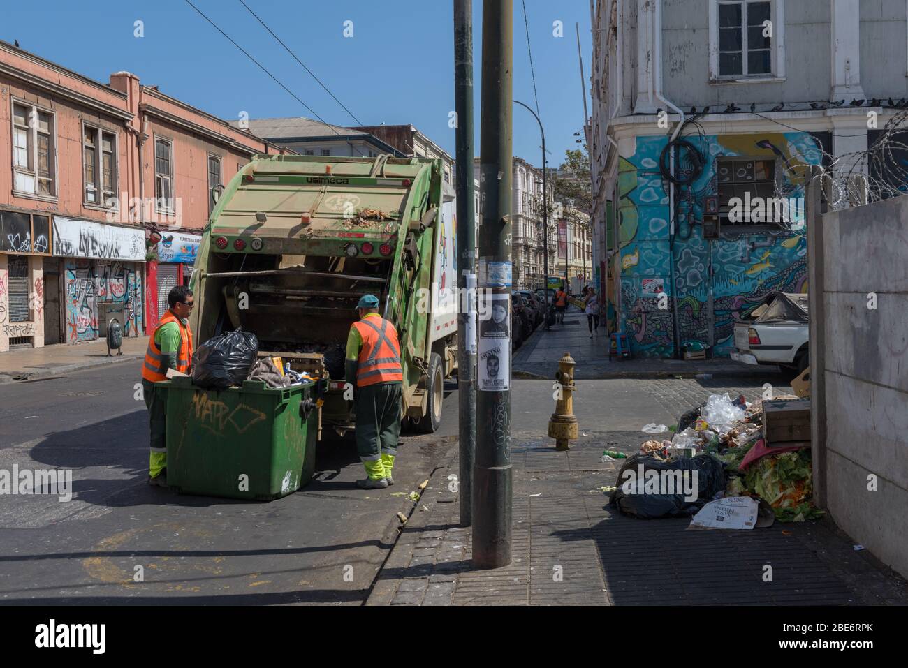 Garbage workers collect houses while collecting garbage containers on the streets of the old town of Valparaiso, Chile Stock Photo