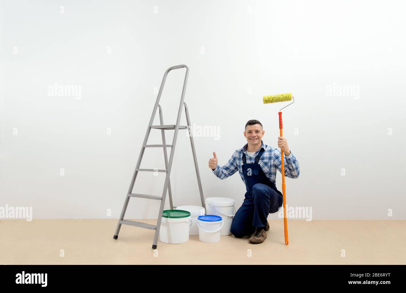worker - painter with tool in the white room. Walls painting concept Stock Photo
