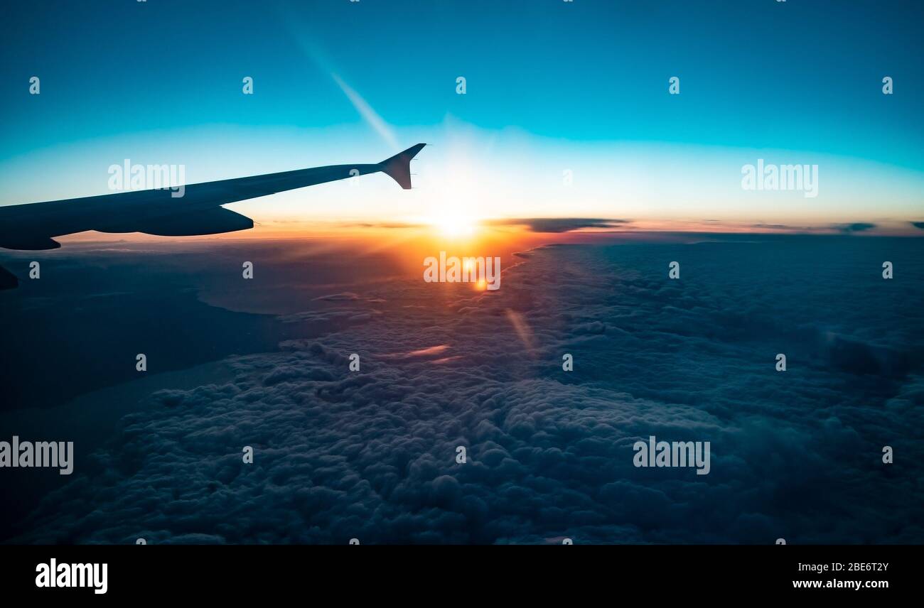 wing passenger airliner fly in sky, on sunset and cloud background Stock Photo