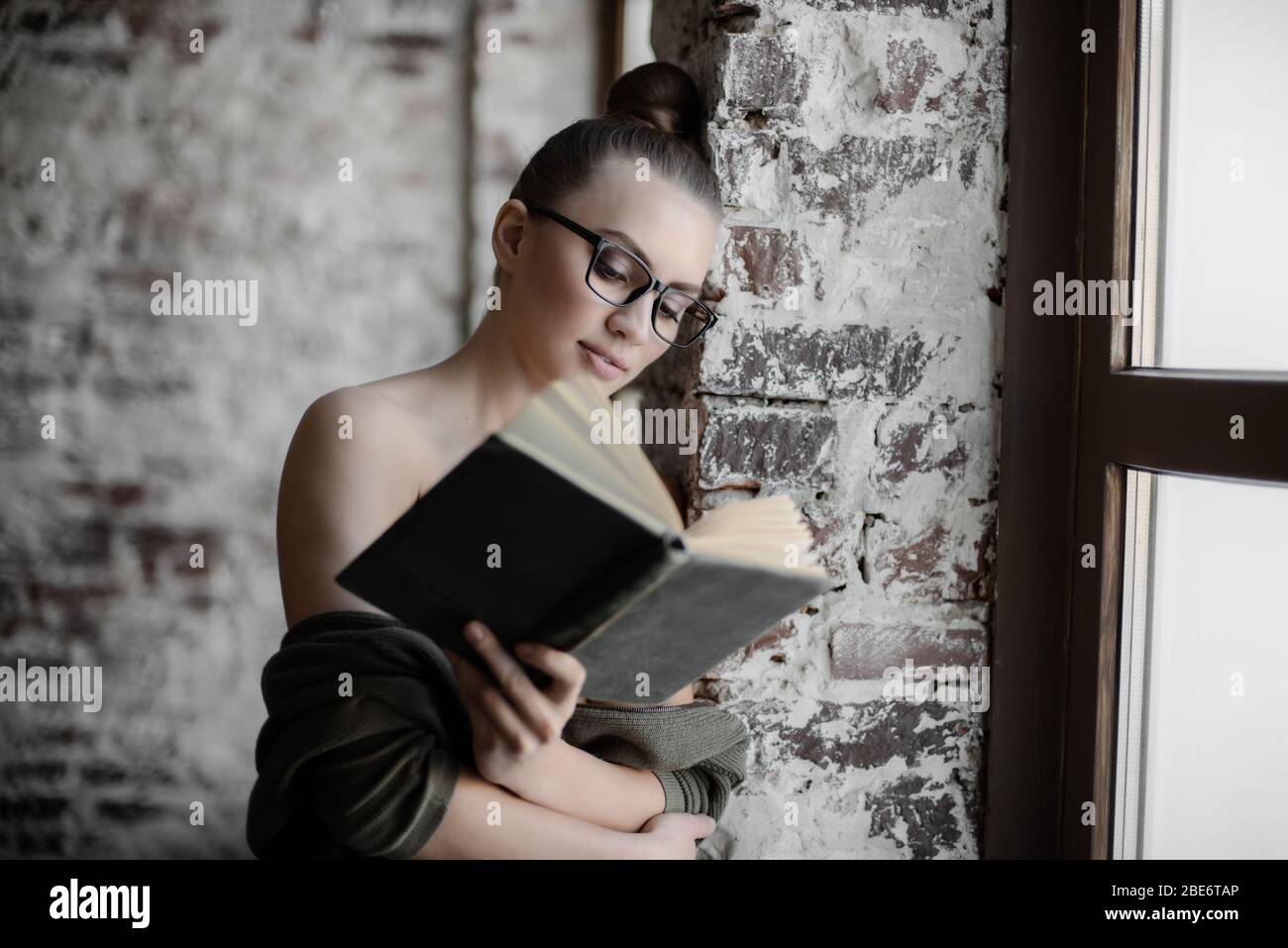 young beauty woman read book near window, horizontal closeup portrait Stock Photo