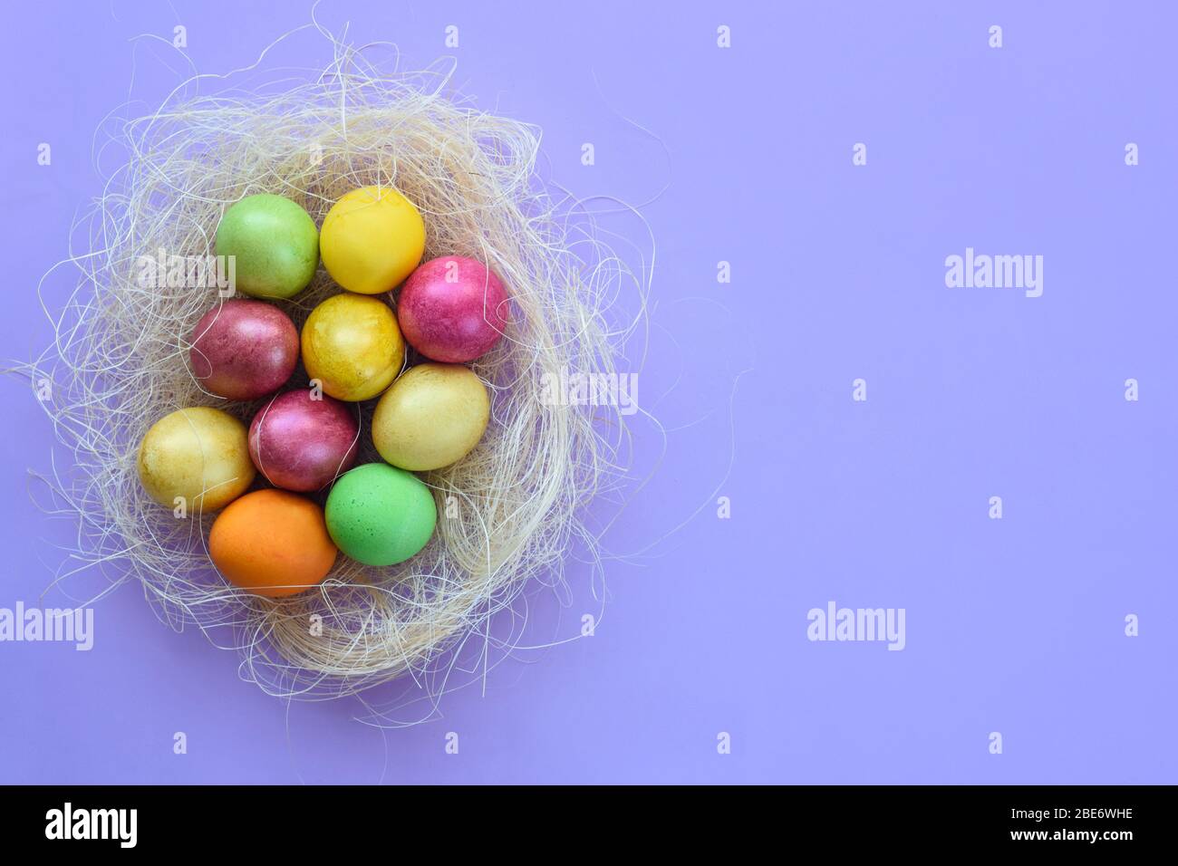 Easter eggs in a makeshift nest on a purple background Stock Photo - Alamy