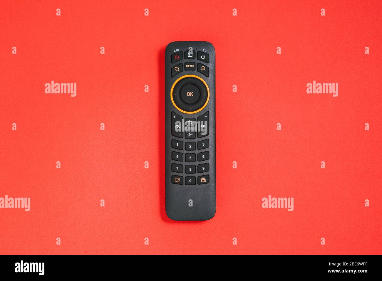 Remote control with buttons on a red background. Smart TV concept. Home entertainment Stock Photo