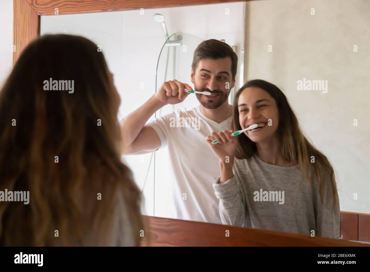 Young family couple having fun while cleaning teeth together Stock Photo