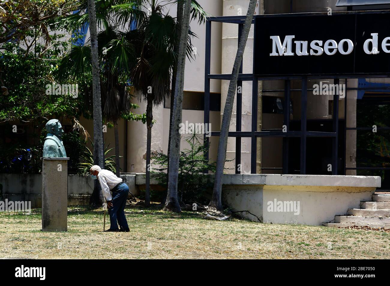 Valencia, Carabobo, Venezuela. 12th Apr, 2020. April 12, 2020. An old man, wearing his face mask, observes a statue in front of themuseum of Culture. The state alarm decreed by Nicolas Maudro that was extended for another month, as a preventive measure against the coronavirus.In the city of Valencia, Carabobo state. Photo: Juan Carlos Hernandez Credit: Juan Carlos Hernandez/ZUMA Wire/Alamy Live News Stock Photo