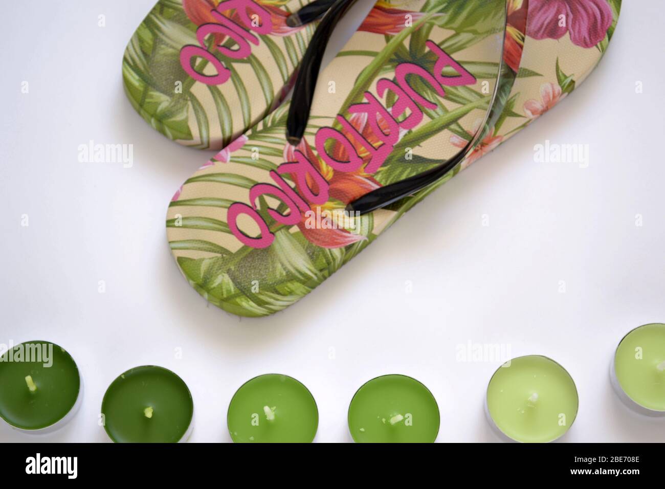 flat lay beach flip-flops from Puerto Rico with green tea light candles on the white background Stock Photo