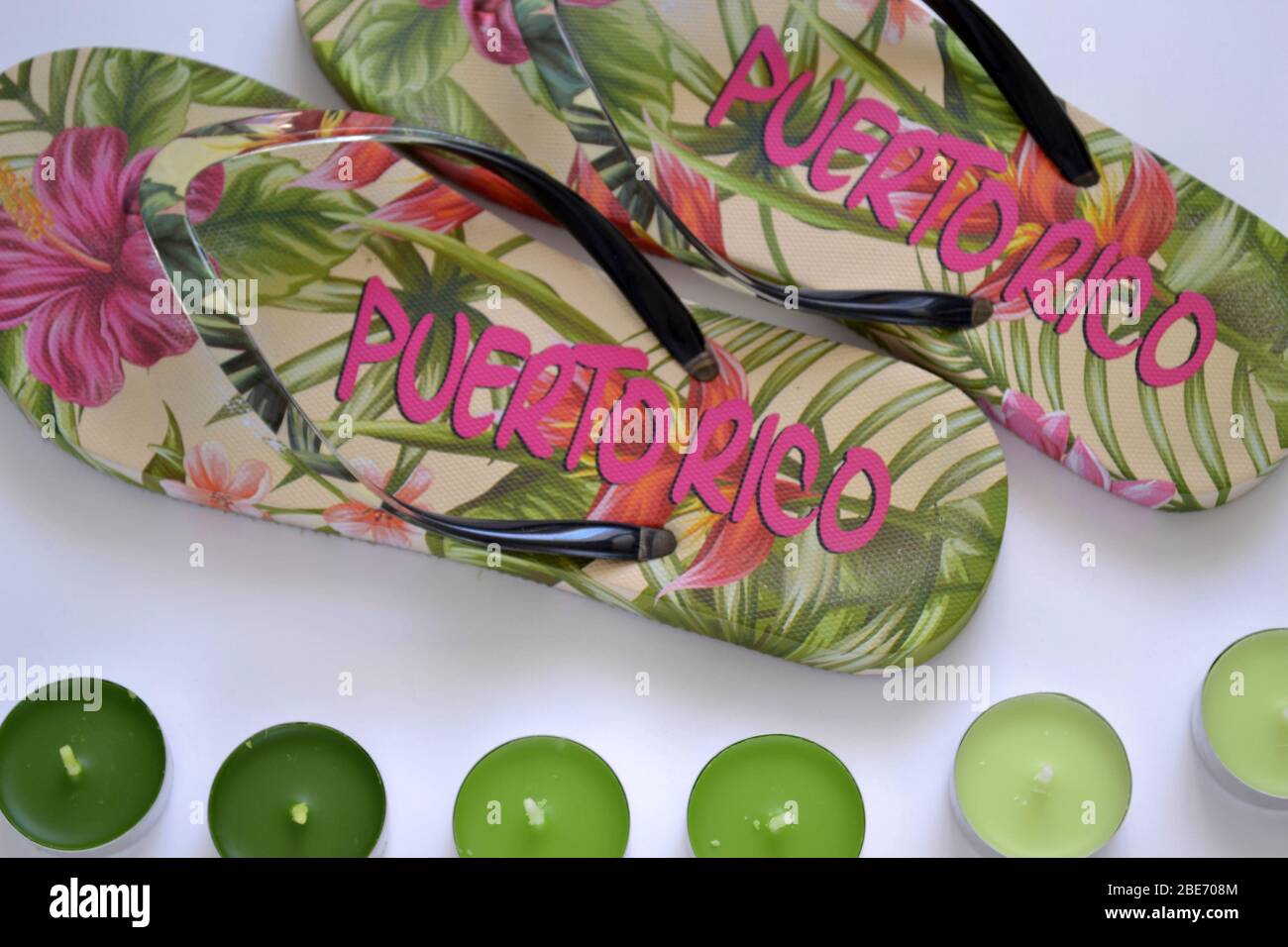 flat lay beach flip-flops from Puerto Rico with green tea light candles on the white background Stock Photo