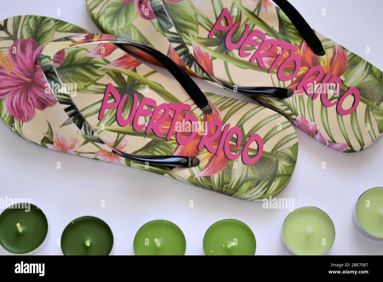 Beach flip-flops from Puerto Rico with green tea light candles, flat lay on the white background Stock Photo