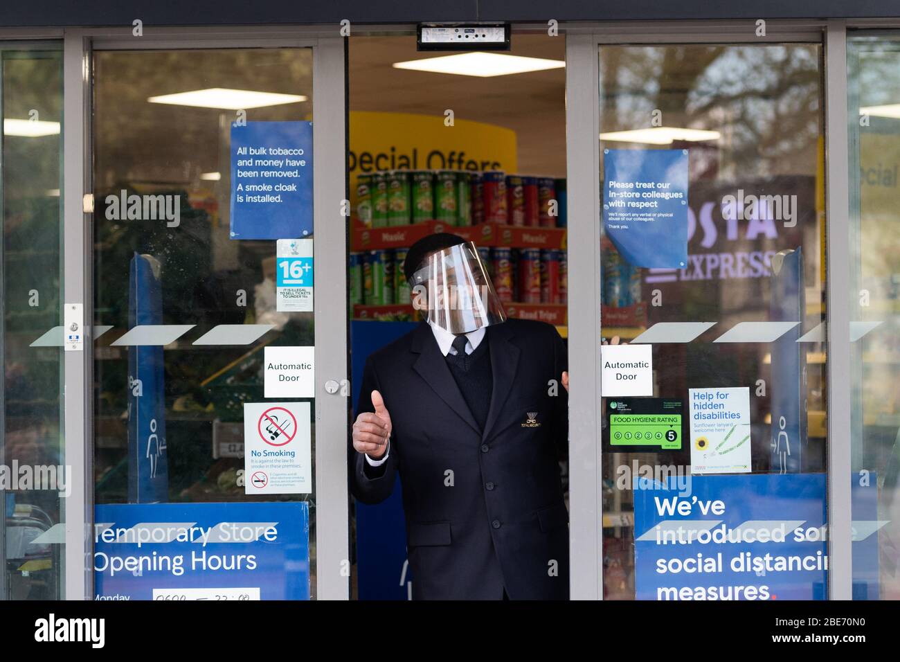 Security Guard Controlling Shoppers Entering And Exiting Tesco Express Supermarket On Easter Sunday Stock Photo Alamy