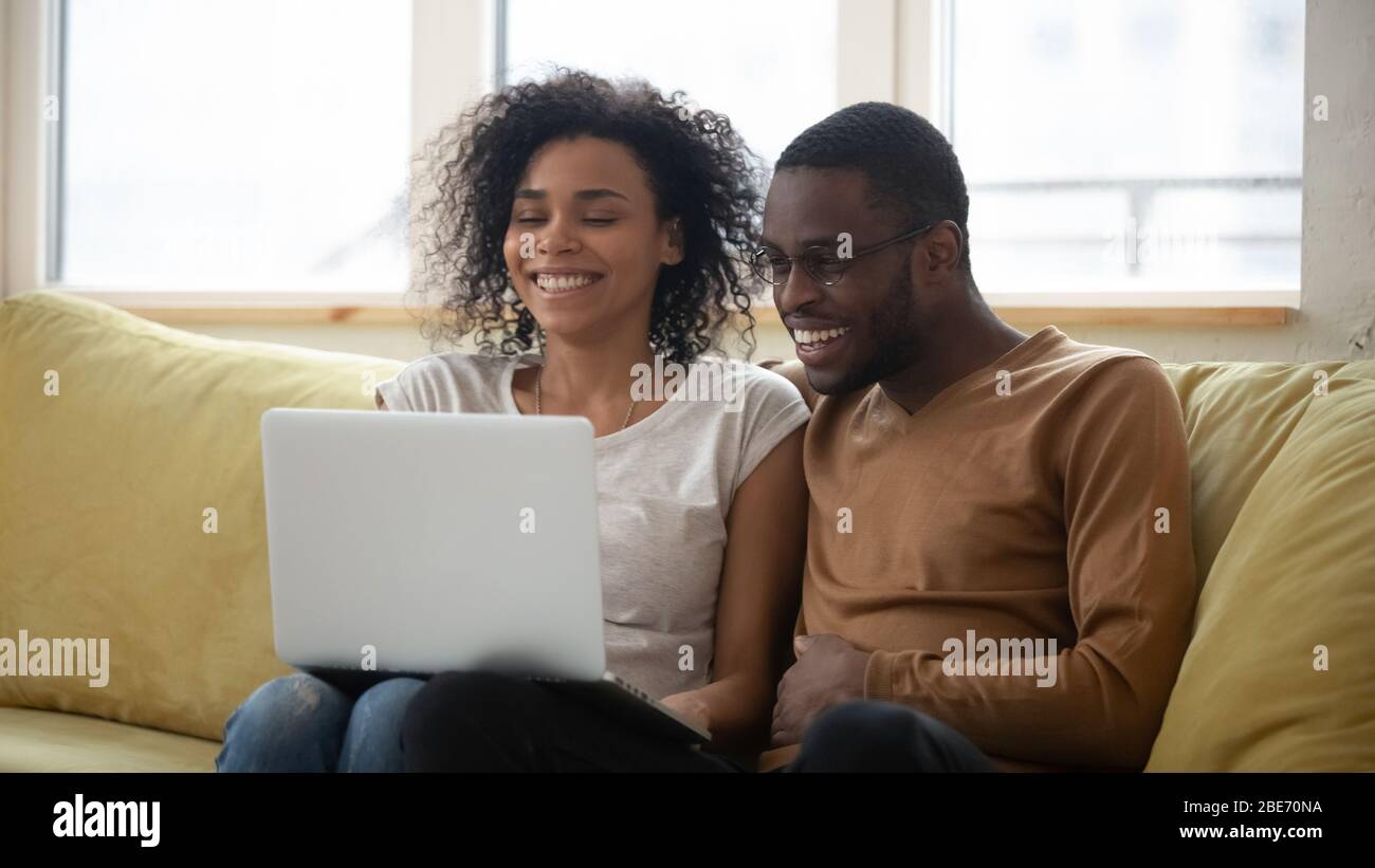 Happy african american family having good time using laptop Stock Photo ...