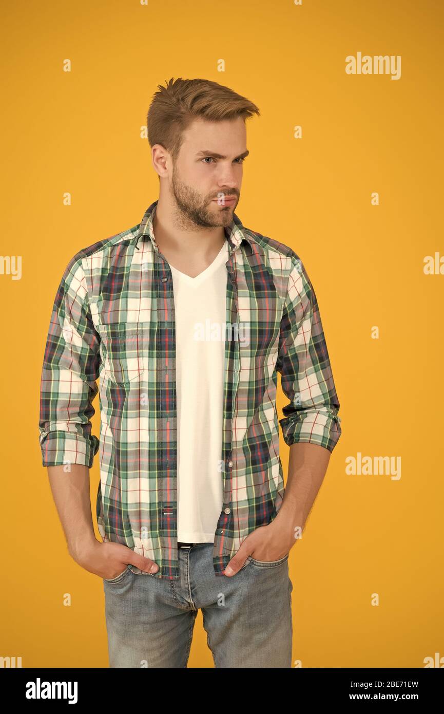 Handsome macho. casual fashion for men. Masculine Outfits And Look. stylish  male in fashionable clothing. handsome man in checkered shirt and jeans.  student yellow background. Make You Look Good Stock Photo -