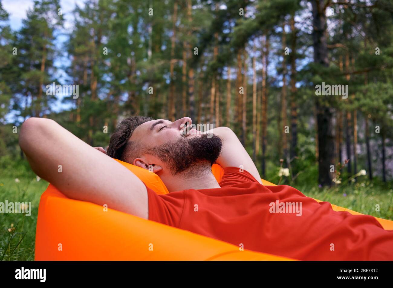 Enjoying life. A young man lies in a bivouac in the forest., relaxation, vacations, lifestyle concept Stock Photo