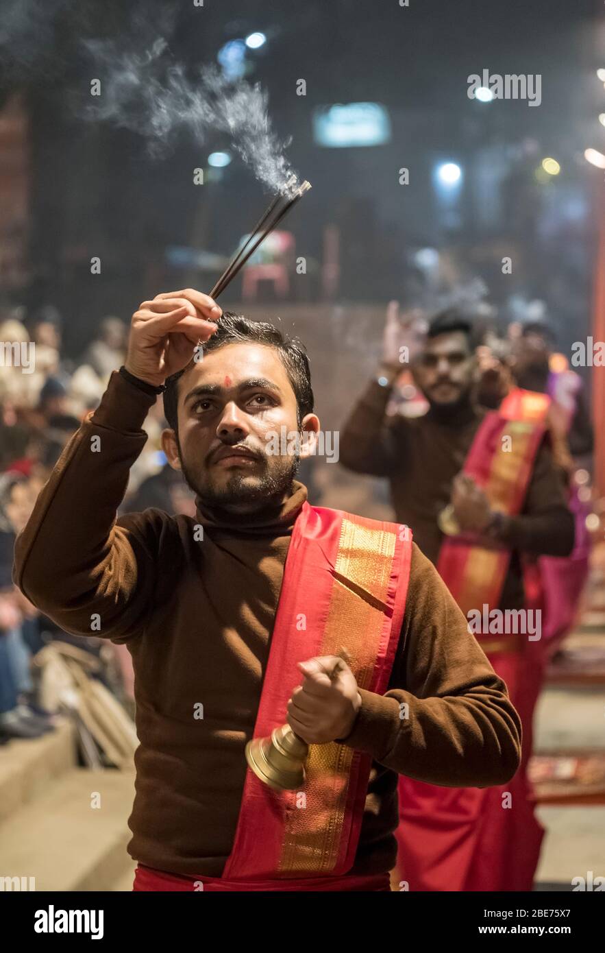 Aarti performance at a Ghat in Varanasi, India with young men performing offerings to the gods with incense Stock Photo