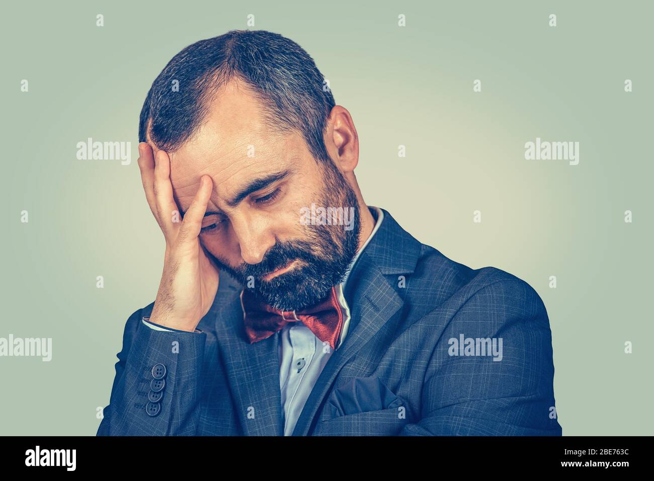 portrait of sad man looking down isolated on light green background ...