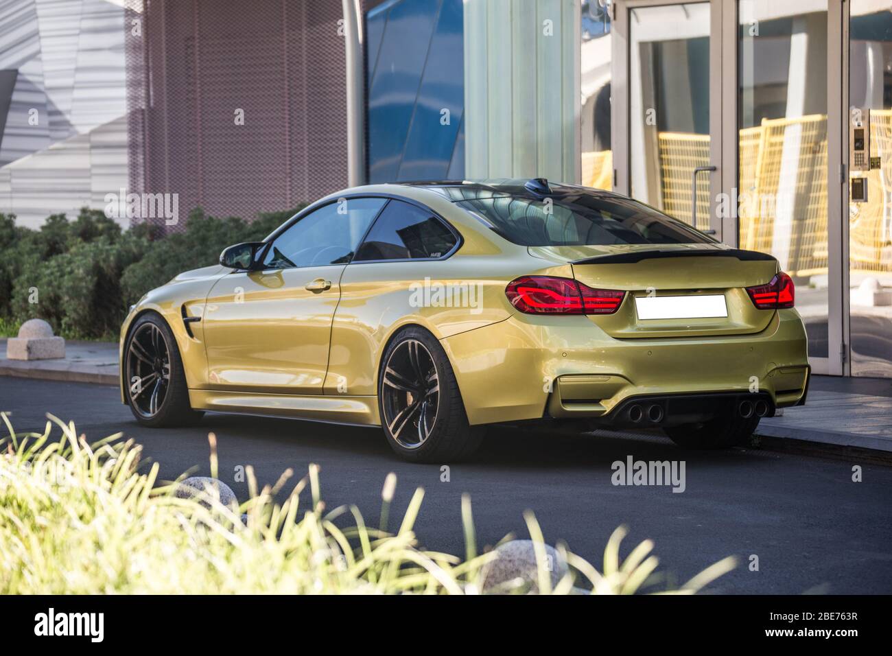 Yellow sport model car with red xenon lights parked in front of an