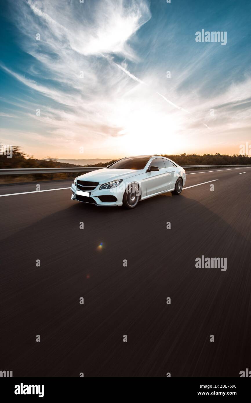 White luxury sedan car driving on the road under the blue sky Stock ...