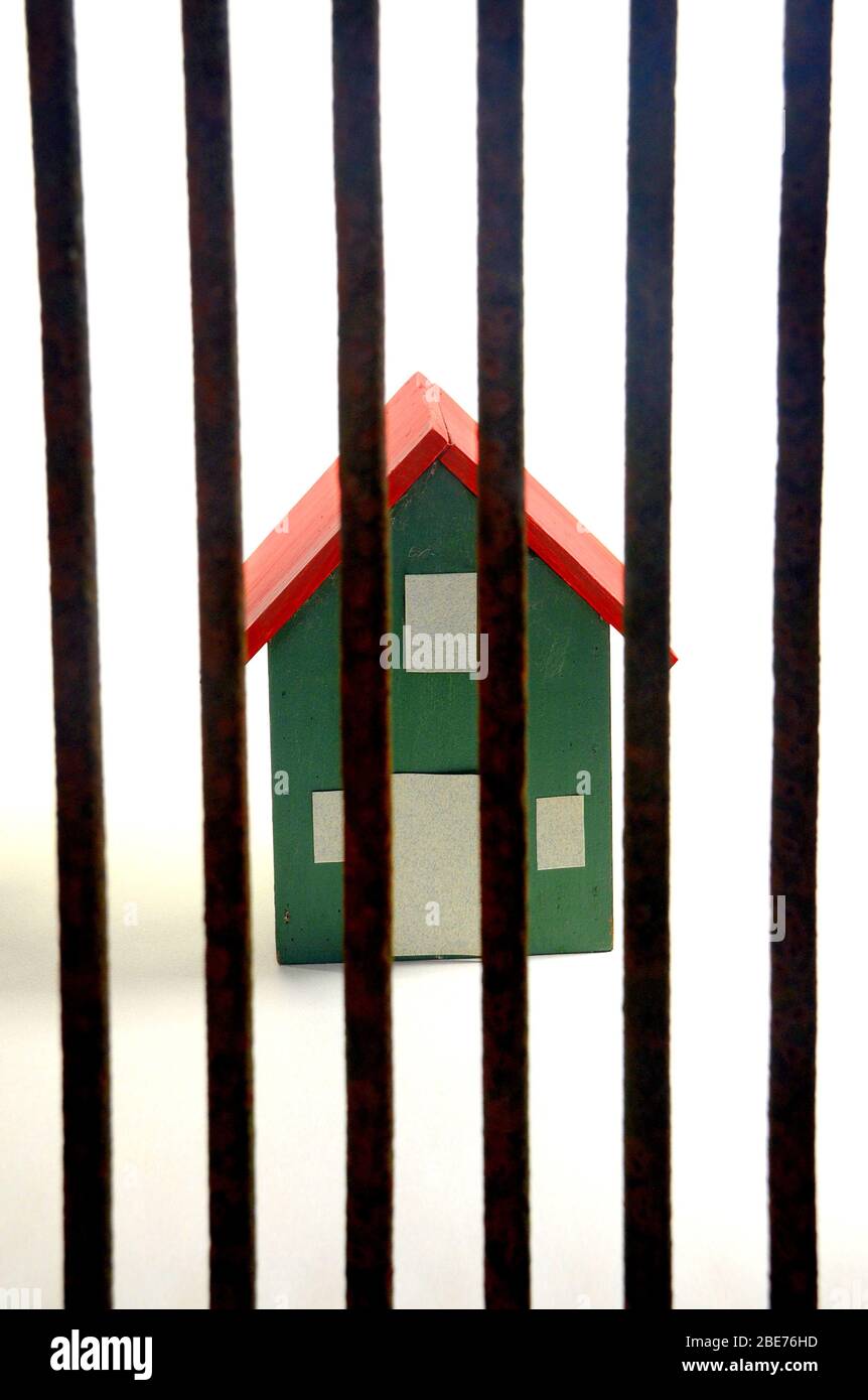 A house behind bars to illustrate the impact on households of the corona virus lockdown Stock Photo