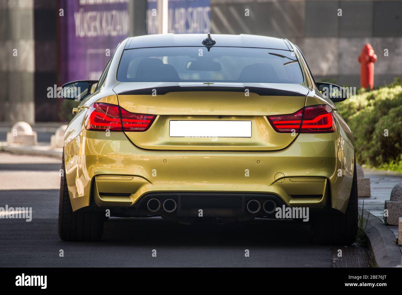 Yellow sport model car with red xenon lights, view from behind Stock