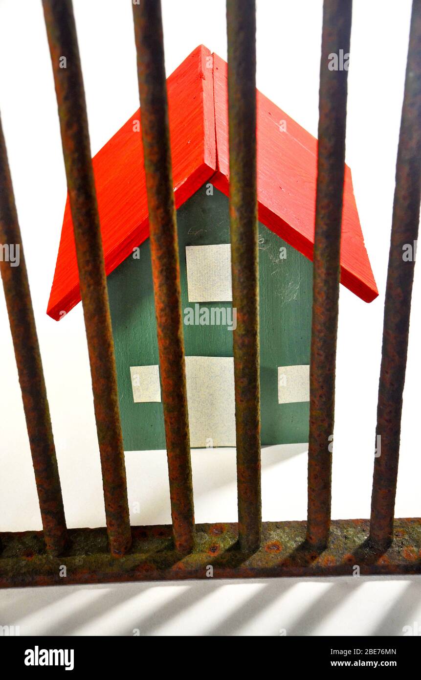 A house behind bars to illustrate the impact on households of the corona virus lockdown Stock Photo