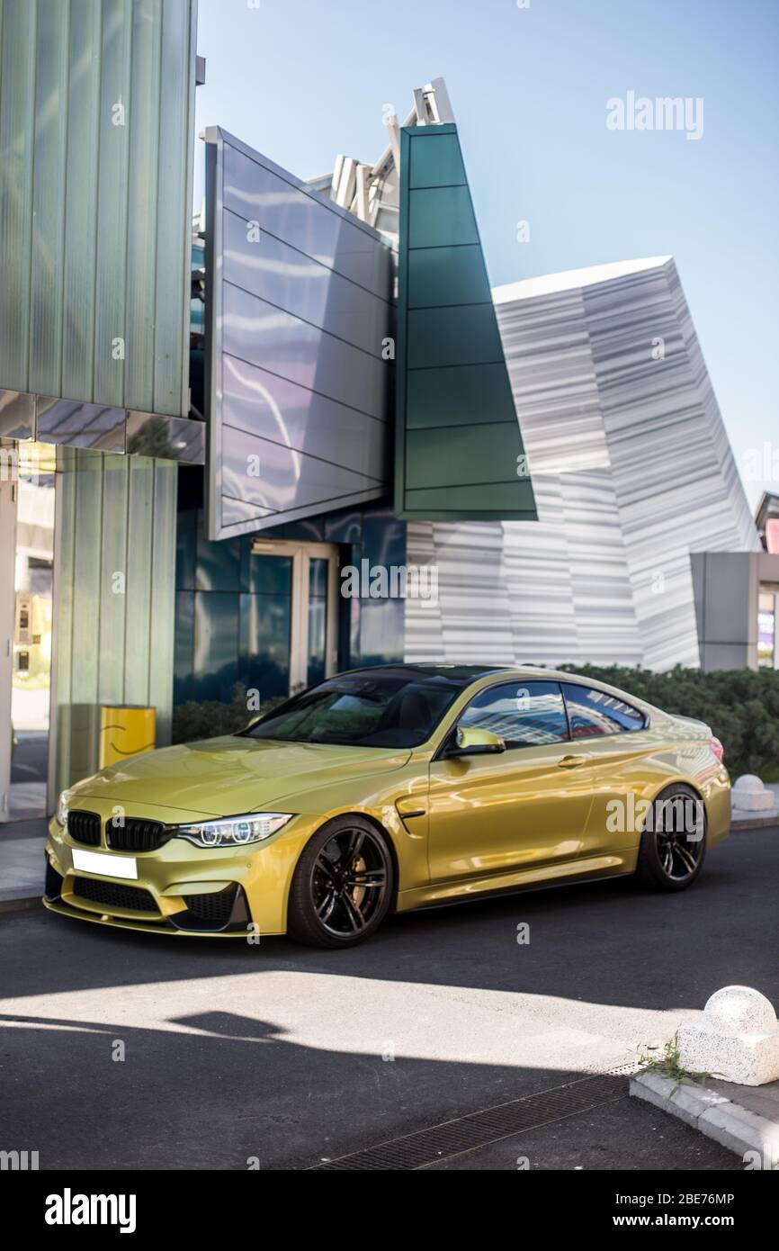 Yellow sport model car in front of a modern architectural building