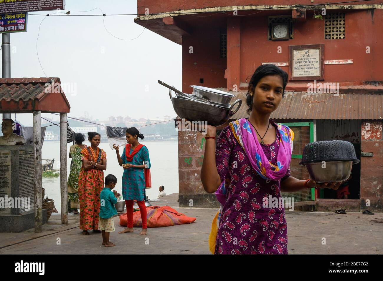 Woman with pots and pans, Mullicj Ghat, Kolkata, India Stock Photo