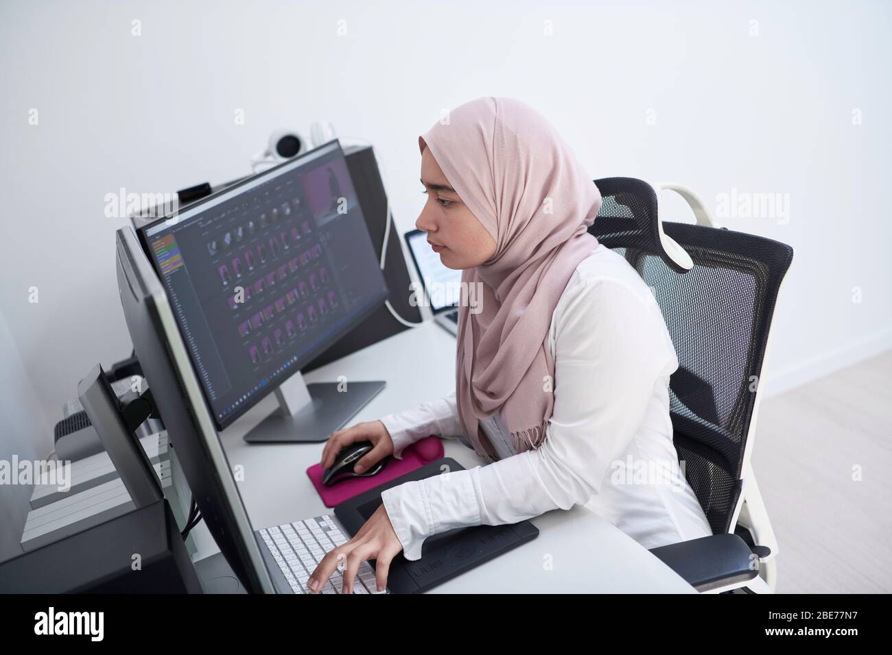 female Arabic creative professional working at home office on desktop ...