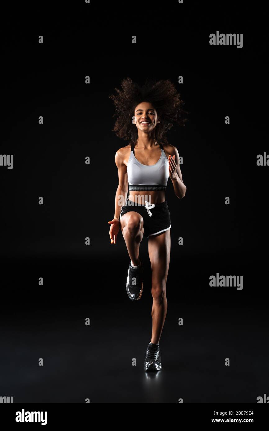 Image of smiling african american woman doing exercise while working ...